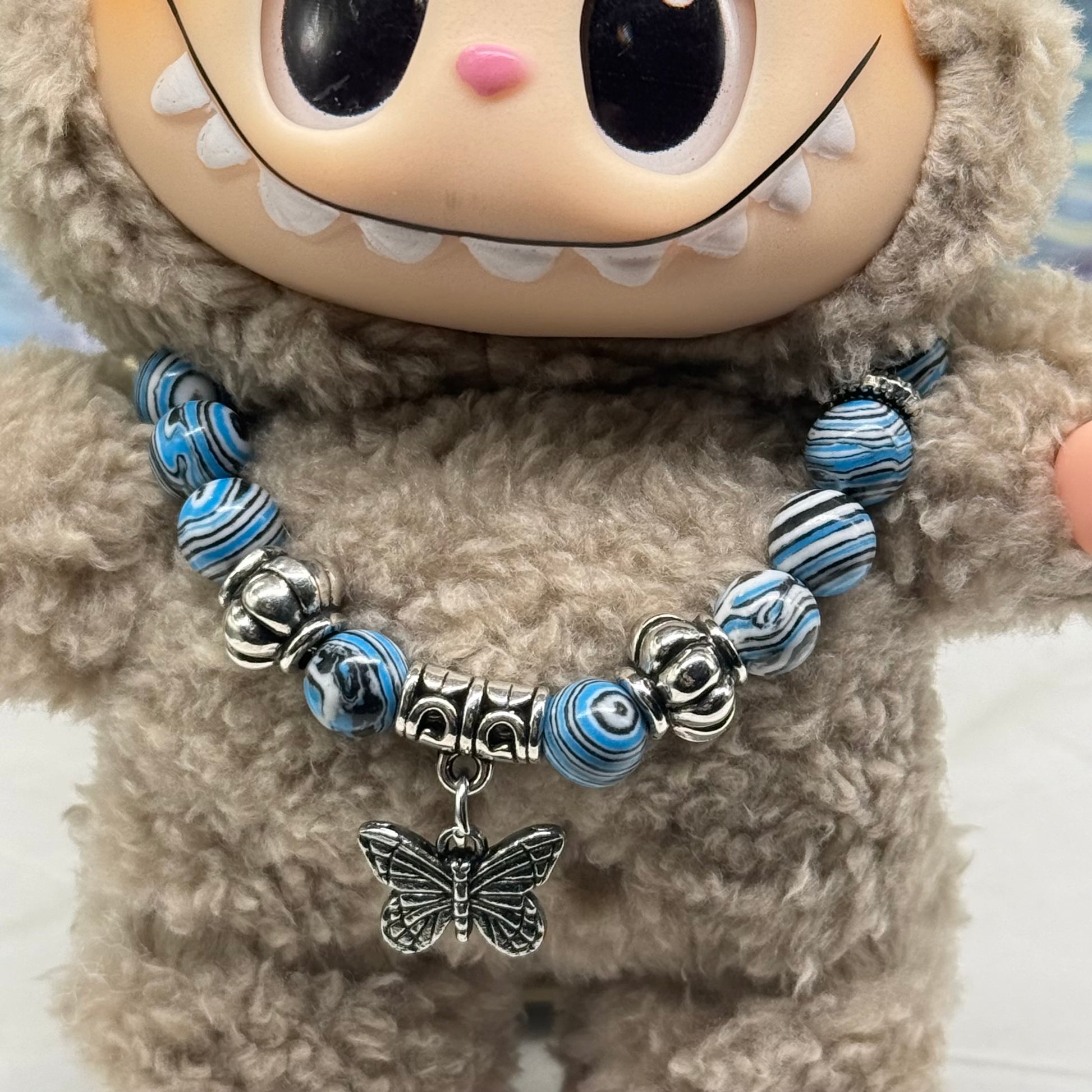 ✨Handmade Jewelry Designed to fit popular 17 to 20 cm (6 to 7 inch) Plushie Labubu Monster Dolls: add a stylish touch to your favorite plushie! ✨

Blue White Black Swirl Glass Beaded Silver Butterfly Charm Necklace