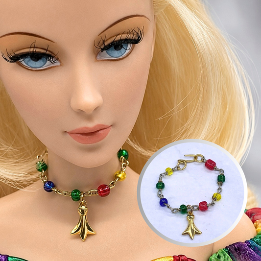 Dress up your favorite doll with this Multi Color Glass Bead Gold Charm Doll Necklace. This necklace is 2-3/4 inches in length. Necklace shown on 16” Madame Alexander - Alex doll