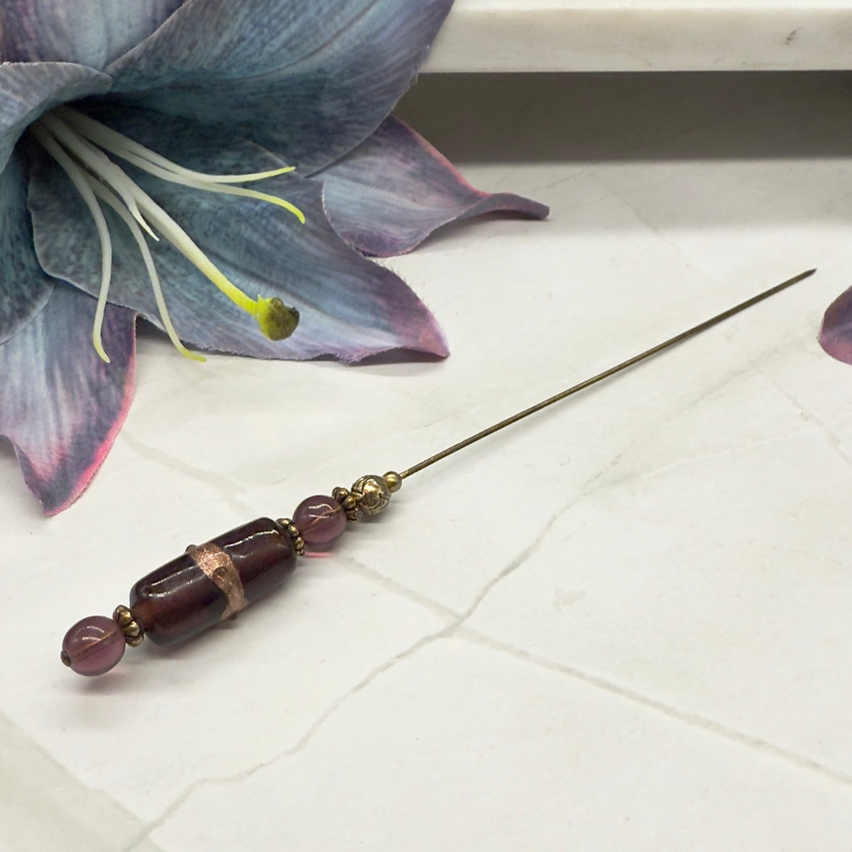 ✨Handmade Vintage Inspired Hatpin, Stick Pin, Gifts for Her, Hat Accessory, Jewelry Decor✨

Purple Glass Gold Accent Cylinder Shaped Hatpin - Stick Pin - measures 6” long.