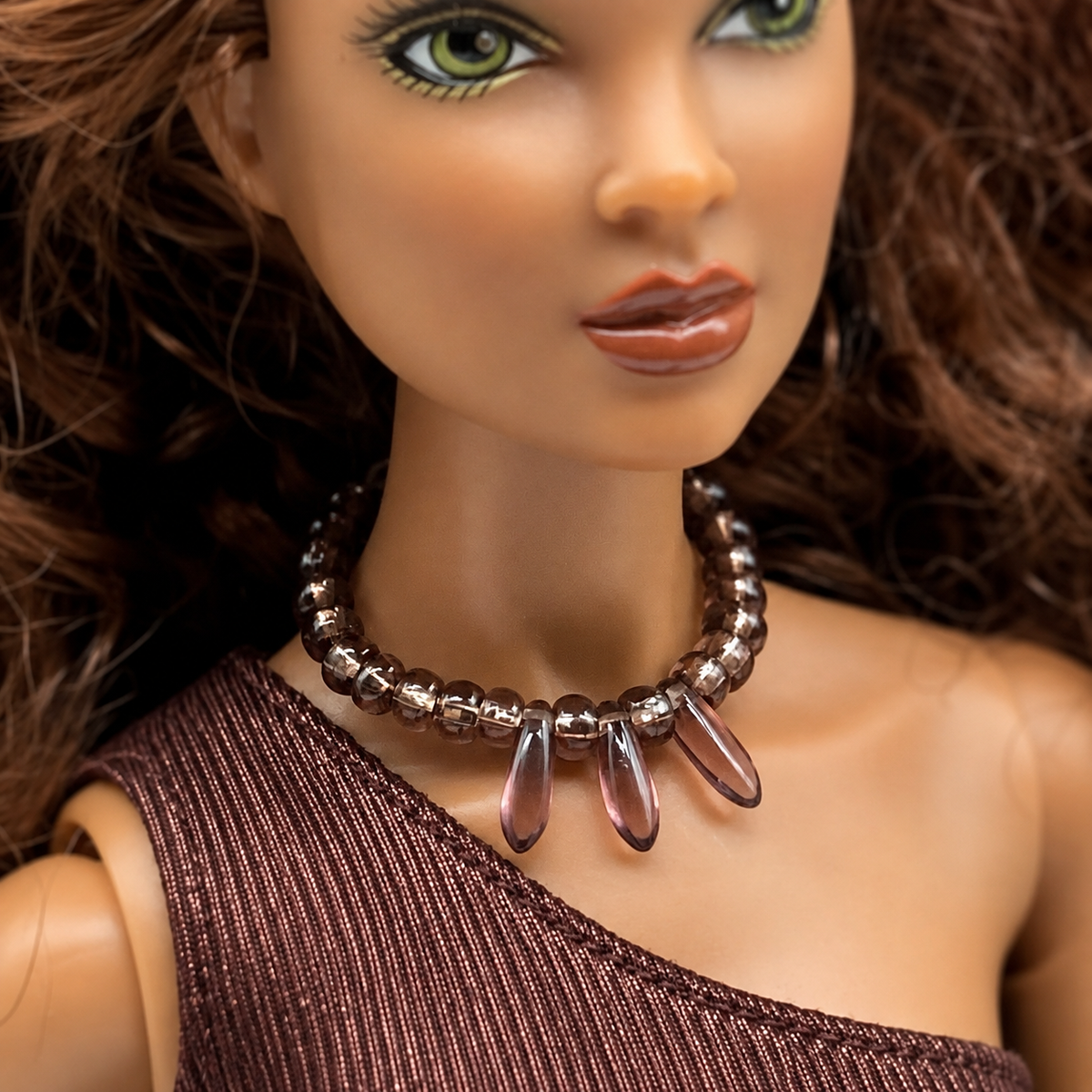 Purple glass beaded choker style necklace with teardrop shaped dangles. Made with bendable gold tone wire. Necklace shown on 16” Spellbound Valentina doll