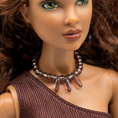 Purple glass beaded choker style necklace with teardrop shaped dangles. Made with bendable gold tone wire. Necklace shown on 16” Spellbound Valentina doll
