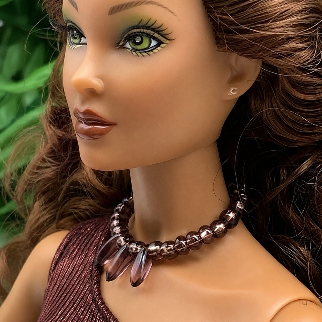 Purple glass beaded choker style necklace with teardrop shaped dangles. Made with bendable gold tone wire. Necklace shown on 16” Spellbound Valentina doll