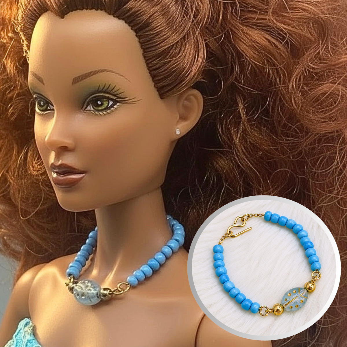 Turquoise blue glass and gold beaded doll necklace. The necklace measures 3.5 inches long. The beads are strung on small gold tone chain. Necklace and shown on 16” Spellbound Valentina doll