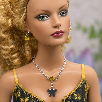 Yellow Rhinestone Silver Butterfly Charm Doll Necklace & Earrings Set • Necklace measures 3 3/4 inches long • Necklace and earrings shown on 16” Tonner - Sydney Chase “Envy” doll