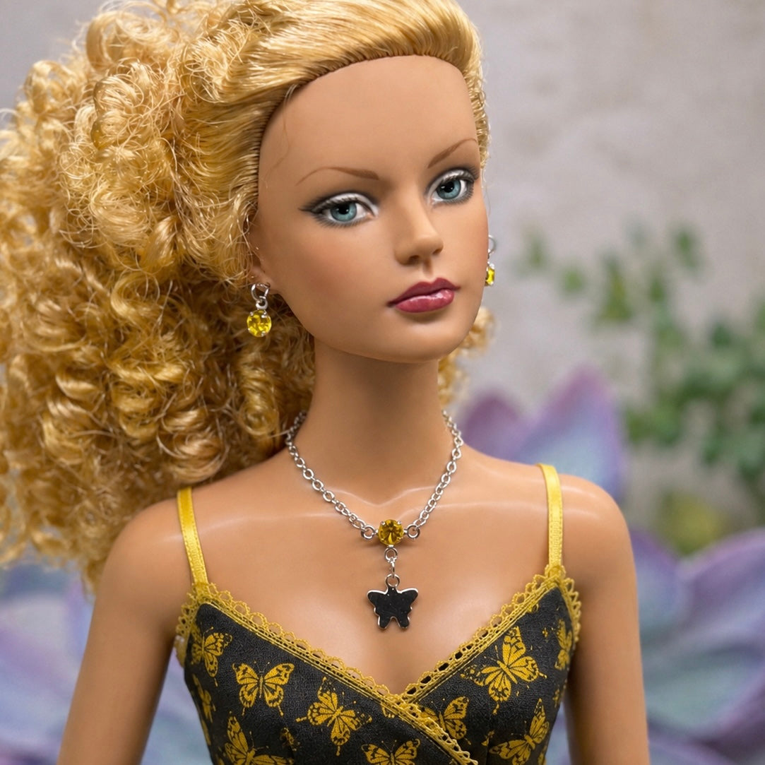 Yellow Rhinestone Silver Butterfly Charm Doll Necklace & Earrings Set • Necklace measures 3 3/4 inches long • Necklace and earrings shown on 16” Tonner - Sydney Chase “Envy” doll